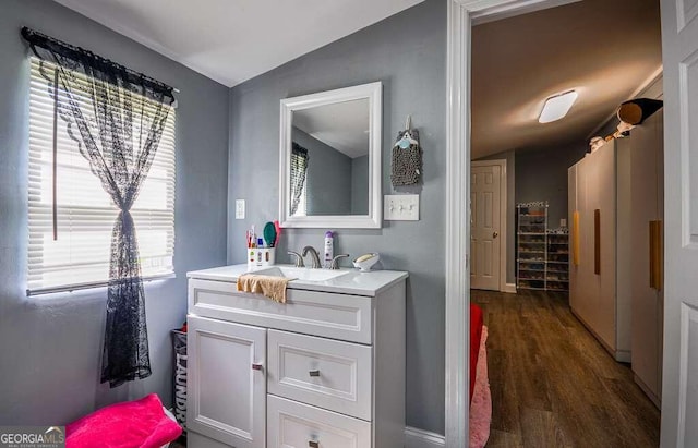 bathroom with lofted ceiling, hardwood / wood-style flooring, and vanity