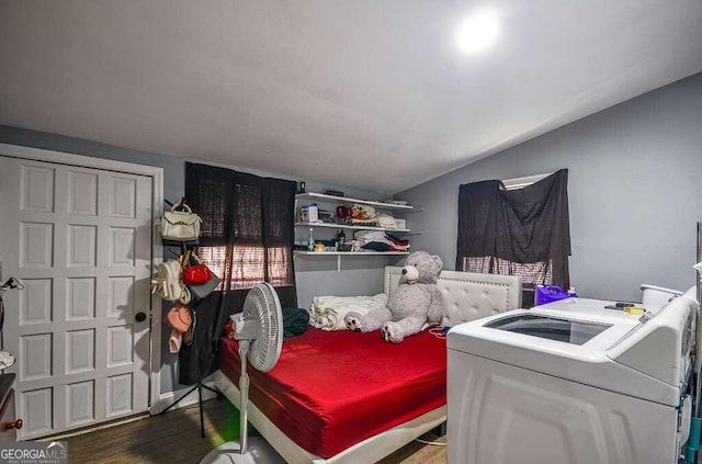 bedroom featuring vaulted ceiling, washer and clothes dryer, and dark hardwood / wood-style floors