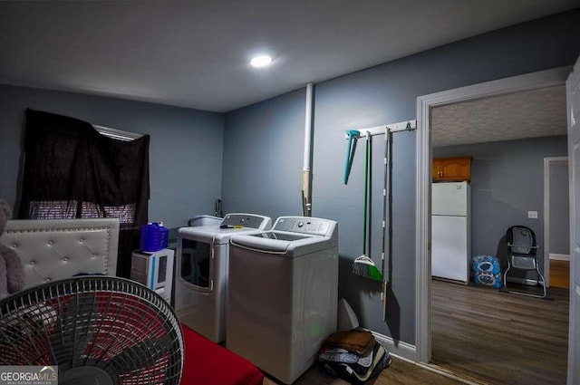 clothes washing area featuring hardwood / wood-style floors and washer and clothes dryer