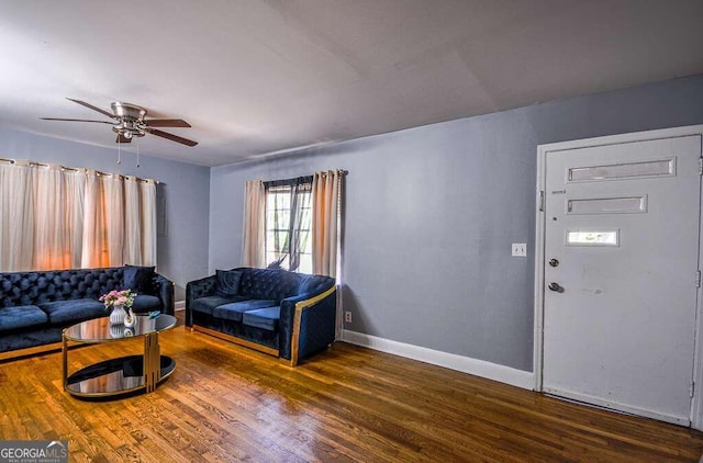 living room with dark wood-type flooring and ceiling fan