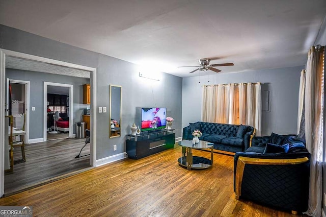 living room featuring ceiling fan and hardwood / wood-style flooring