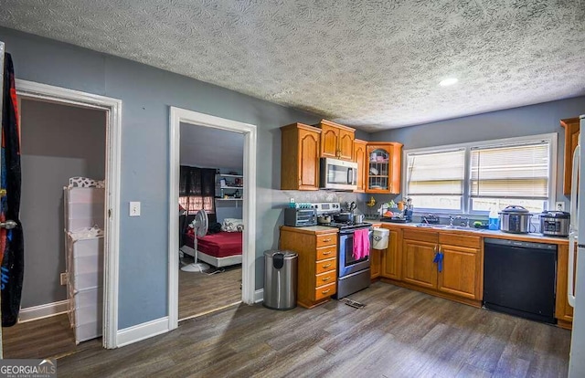 kitchen featuring a textured ceiling, stainless steel appliances, sink, and dark hardwood / wood-style flooring