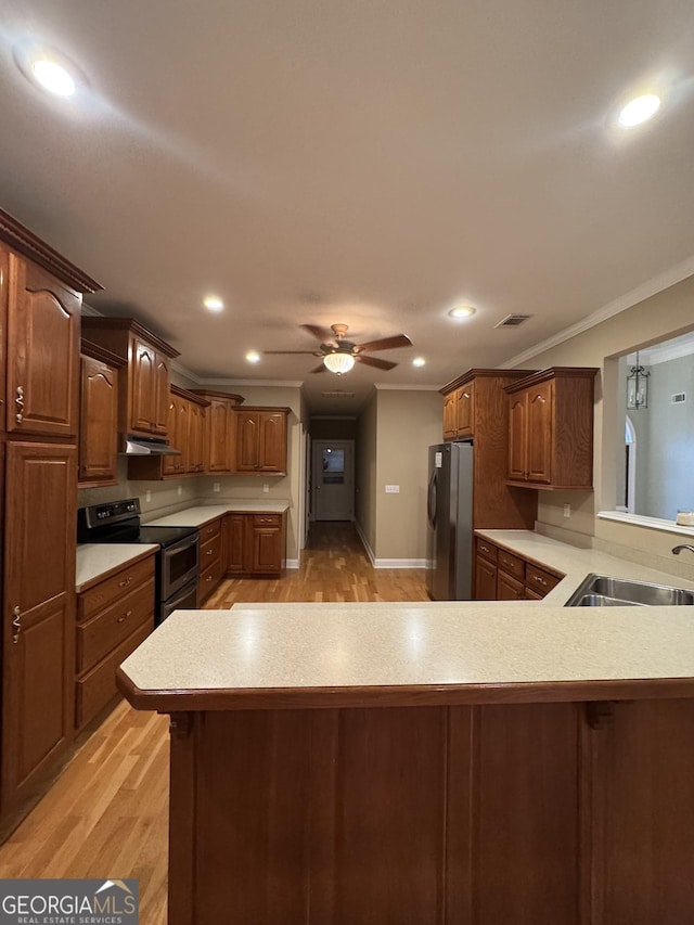 kitchen with kitchen peninsula, light wood-type flooring, ornamental molding, stainless steel appliances, and sink