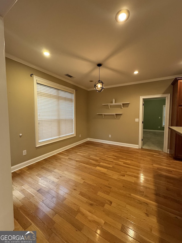 unfurnished living room featuring light wood-type flooring and ornamental molding