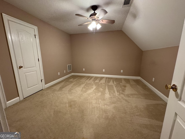 additional living space featuring carpet flooring, ceiling fan, a textured ceiling, and vaulted ceiling