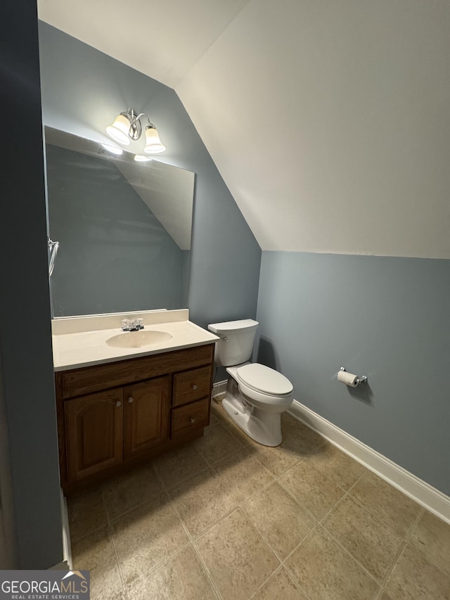 bathroom with vanity, toilet, and vaulted ceiling