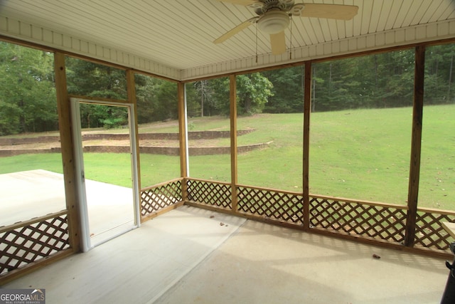 unfurnished sunroom with ceiling fan and wooden ceiling