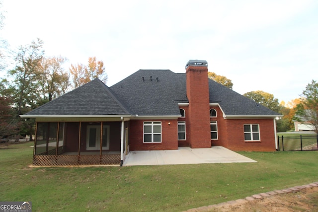 back of house with a lawn, a sunroom, and a patio area