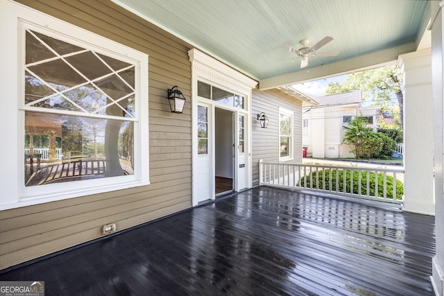 wooden deck featuring covered porch and ceiling fan