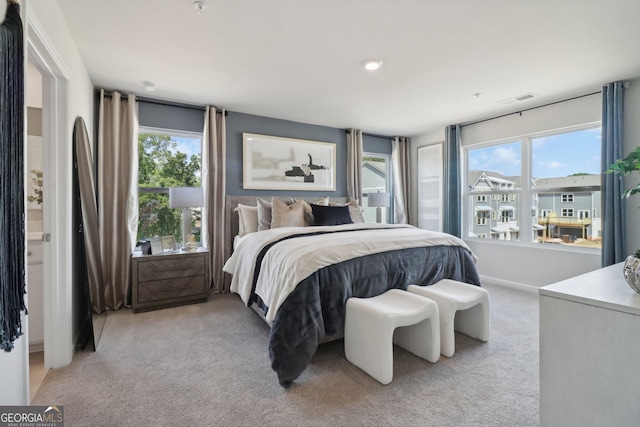 bedroom featuring multiple windows and light colored carpet