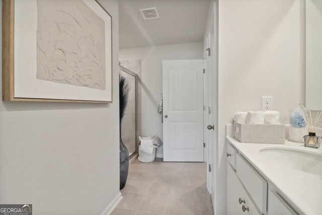 bathroom featuring vanity, tile patterned floors, and a shower with shower door