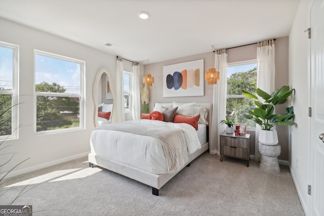 bedroom with light carpet and multiple windows