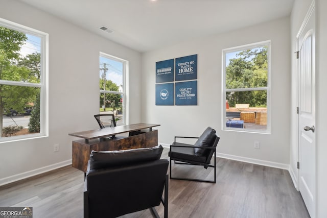 sitting room with hardwood / wood-style floors and a healthy amount of sunlight