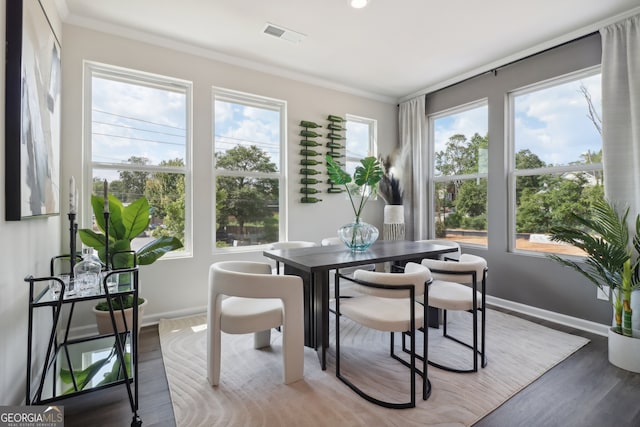 dining space with crown molding, hardwood / wood-style flooring, and a wealth of natural light