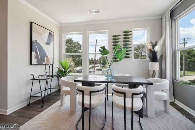 dining space featuring ornamental molding, plenty of natural light, and dark hardwood / wood-style floors