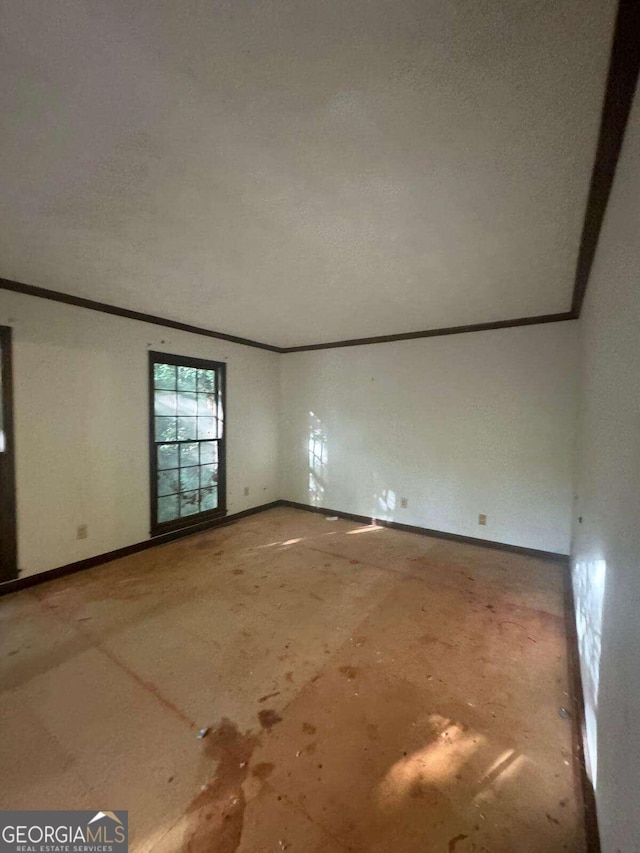 unfurnished room featuring ornamental molding and a textured ceiling