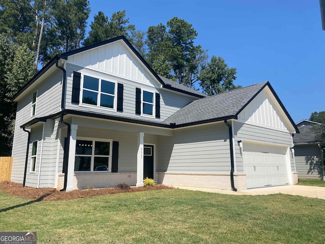 view of front of house with a garage, a front yard, and covered porch