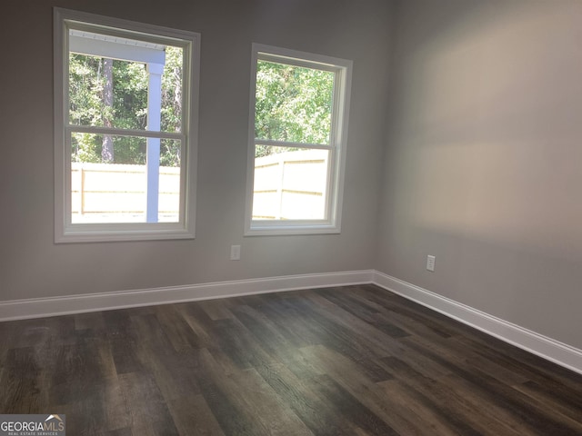 empty room featuring dark wood finished floors and baseboards