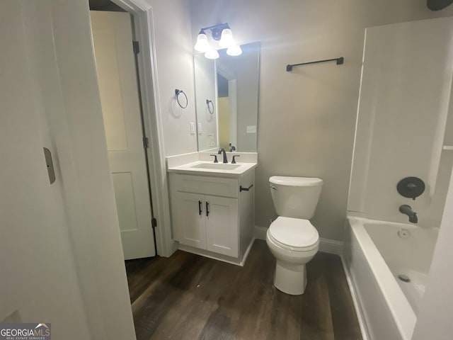 full bathroom with toilet, wood finished floors, bathing tub / shower combination, vanity, and baseboards