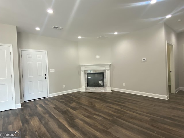 unfurnished living room with dark wood-type flooring, recessed lighting, visible vents, and a fireplace