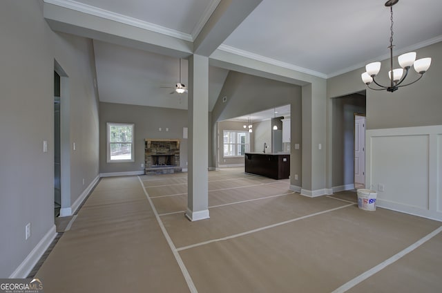 unfurnished living room featuring a fireplace, crown molding, ceiling fan with notable chandelier, and vaulted ceiling