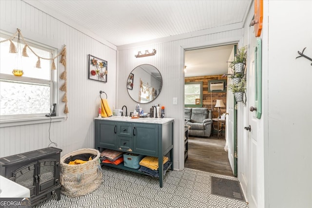 interior space featuring wooden walls, hardwood / wood-style floors, vanity, an AC wall unit, and ornamental molding