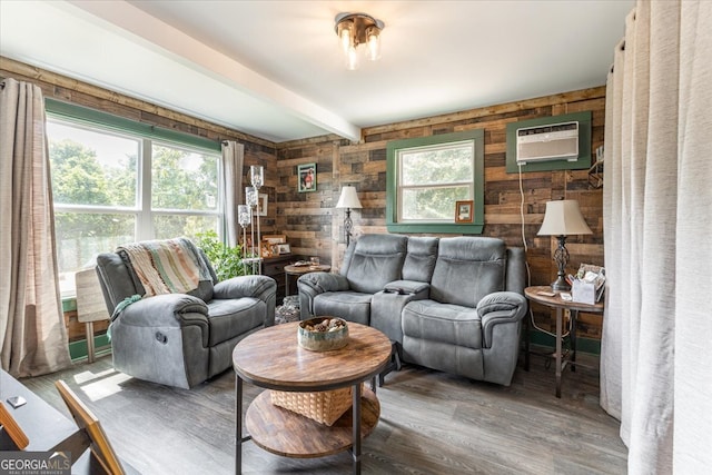 living room featuring wood walls, beamed ceiling, wood-type flooring, and a wall mounted air conditioner