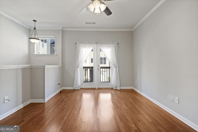 empty room featuring ceiling fan, crown molding, and wood-type flooring