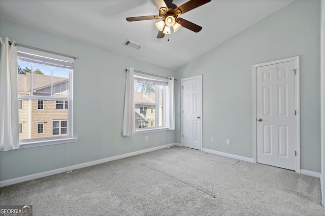 unfurnished room with ceiling fan, light colored carpet, and lofted ceiling