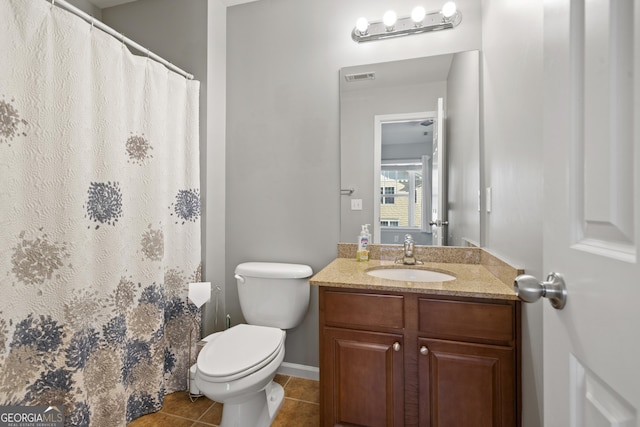 bathroom with tile patterned flooring, vanity, and toilet