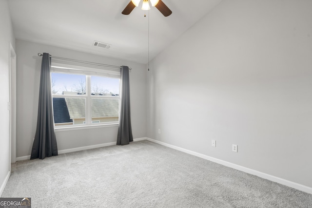 empty room with ceiling fan, light colored carpet, and vaulted ceiling