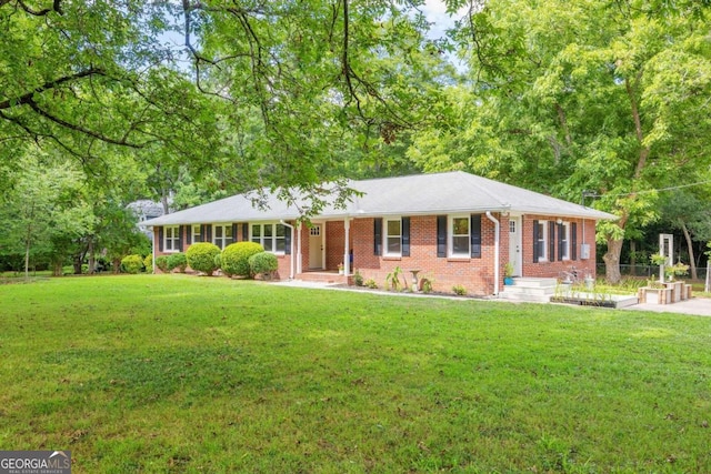 ranch-style home featuring a front lawn and covered porch