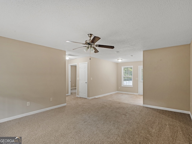 carpeted spare room with ceiling fan and a textured ceiling