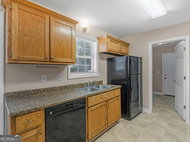 kitchen featuring black appliances, a textured ceiling, and sink