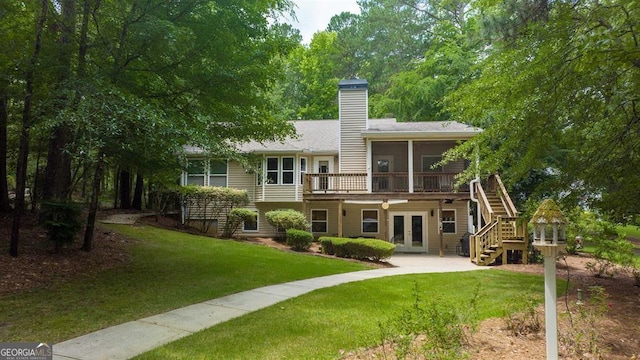 back of property with french doors, a yard, and a sunroom