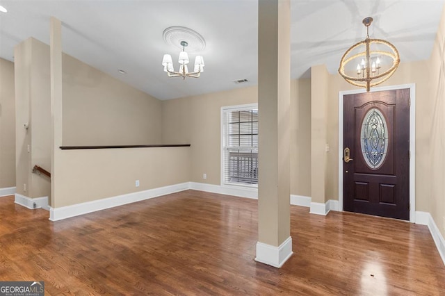 foyer entrance with dark hardwood / wood-style flooring and an inviting chandelier