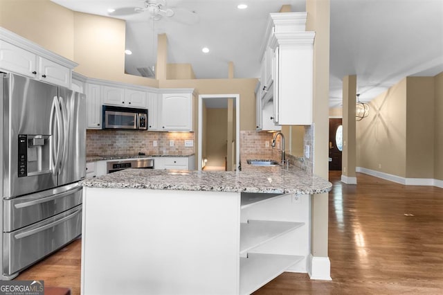 kitchen with light stone counters, stainless steel appliances, sink, dark hardwood / wood-style floors, and white cabinetry