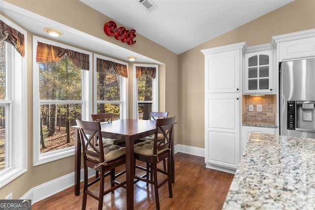 dining space featuring dark hardwood / wood-style flooring and lofted ceiling