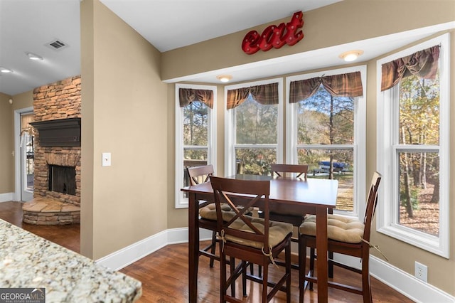 dining space with dark hardwood / wood-style floors and a fireplace