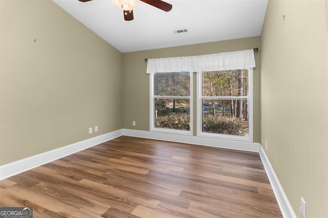 spare room with wood-type flooring, vaulted ceiling, and ceiling fan