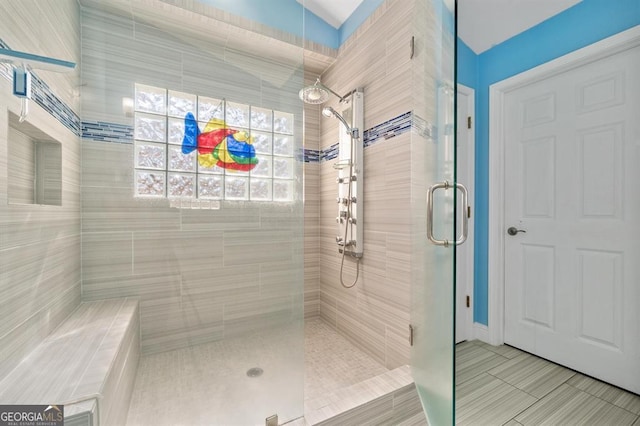 bathroom featuring tile patterned flooring, an enclosed shower, and lofted ceiling