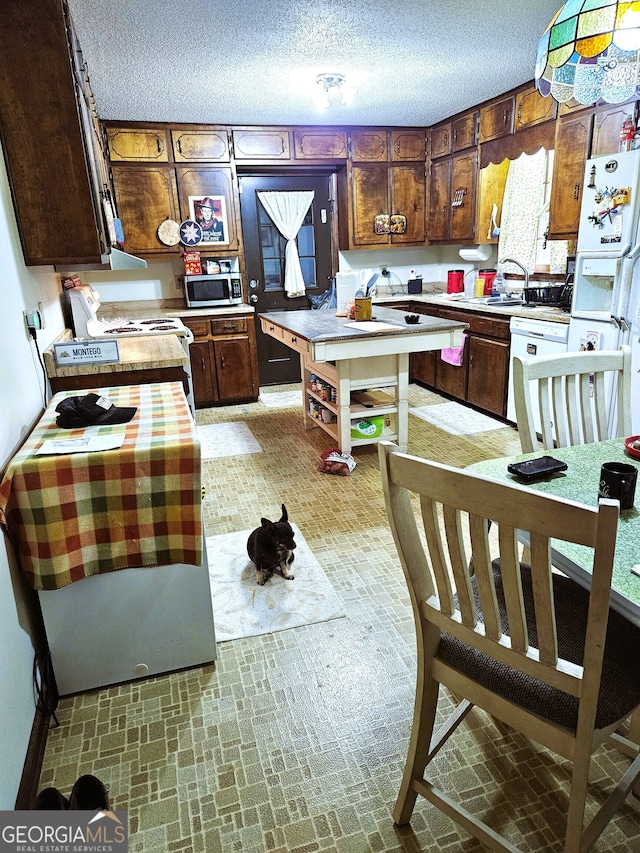 kitchen featuring white appliances and a textured ceiling