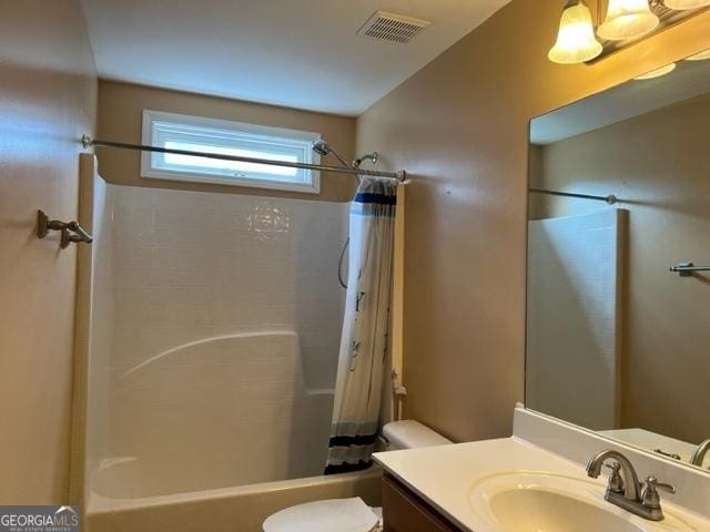 full bathroom featuring toilet, shower / bath combination with curtain, and vanity