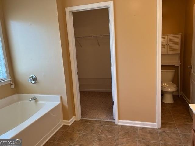 bathroom featuring toilet and a washtub