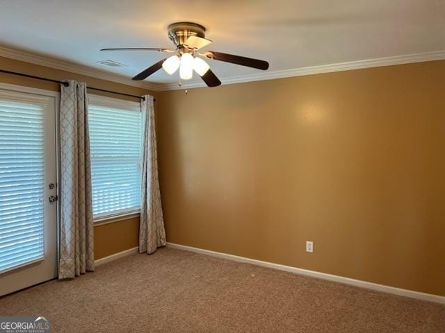 carpeted spare room featuring ceiling fan and crown molding