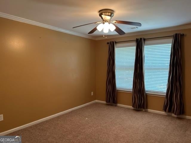 empty room featuring ceiling fan, carpet flooring, and crown molding