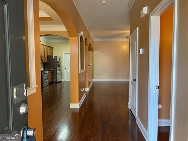 corridor featuring crown molding and dark wood-type flooring