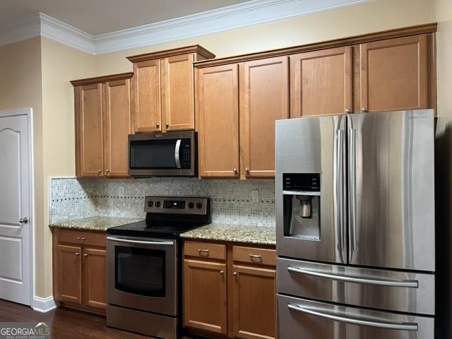 kitchen featuring dark wood-type flooring, stainless steel appliances, backsplash, and light stone countertops