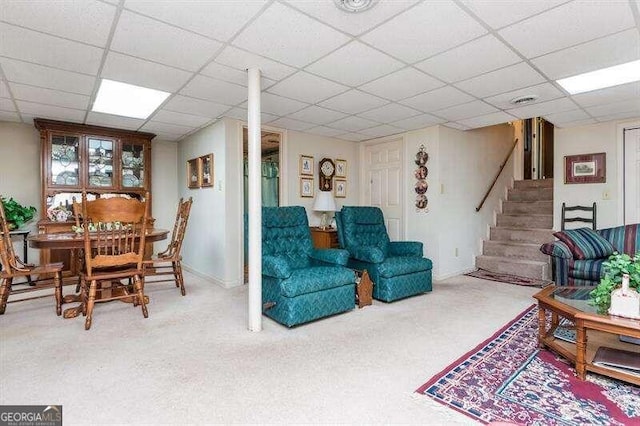 living room with a paneled ceiling and carpet flooring