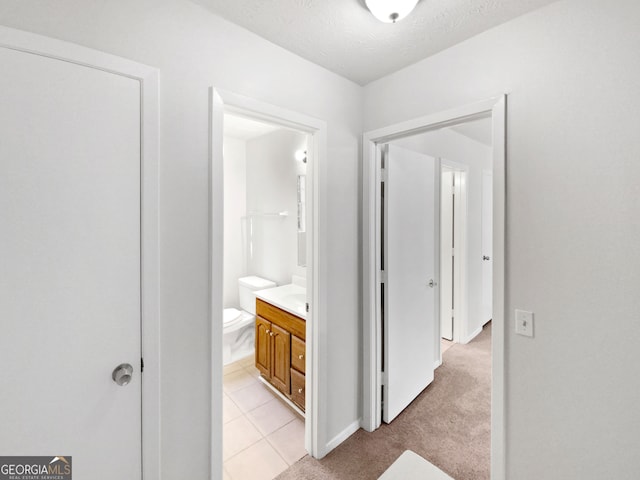 hallway with light tile patterned floors and a textured ceiling